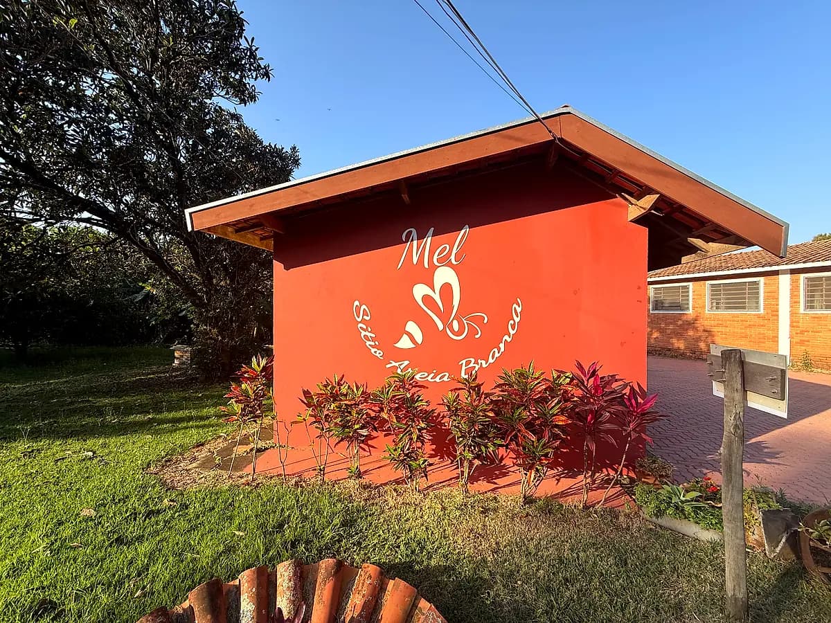Prédio da loja do sítio com a marca Mel Sítio Areia Branca pintada na parede